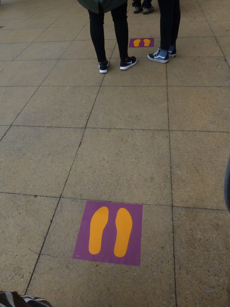 Oznake na tlu za održavanje distance u redu tokom pandemije COVID-19